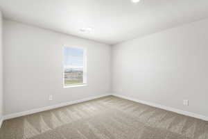Carpeted empty room featuring baseboards