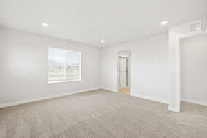 Unfurnished bedroom featuring light carpet, baseboards, and recessed lighting