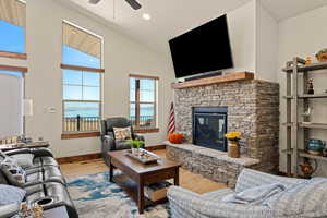 Living area featuring Bear Lake views, a cultured stone fireplace, high vaulted ceiling and remote control UV sunshades on  the windows