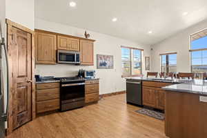 Kitchen featuring granite countertops, recessed lighting, cathedral ceiling, GE Slate appliances