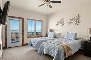 Carpeted en-suite bedroom featuring a Bear Lake view, door to deck, UV sunshades
