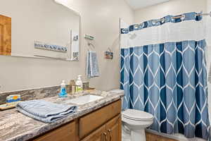 Main floor full bathroom featuring large countertop, tile shower over tub