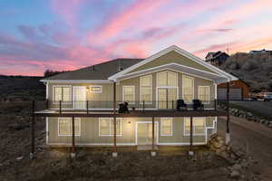 view of home  at dusk with 52' Trex deck and full walk-out  lower level