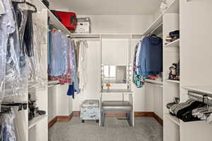 Spacious walk-in closet with carpet, dressing table with lighting