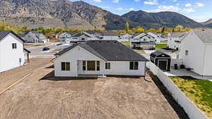Back of property with a fenced backyard, a mountain view, and a residential view