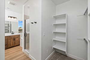 Full bath with baseboards, visible vents, vanity, and a stall shower