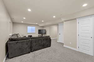 Living area with recessed lighting, carpet, visible vents, and baseboards