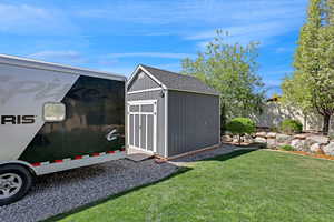 View of yard with an outdoor structure and a storage unit