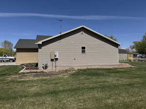 View of side of home with a yard