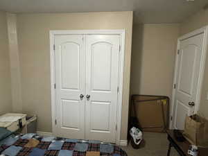 Carpeted bedroom featuring a closet and baseboards