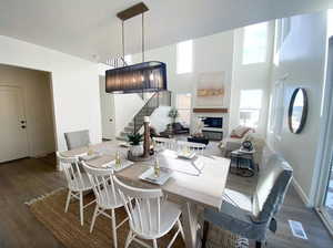 Dining room featuring a glass covered fireplace, stairway, baseboards, and wood finished floors