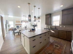 Kitchen featuring a center island, a sink, light wood-type flooring, backsplash, and recessed lighting