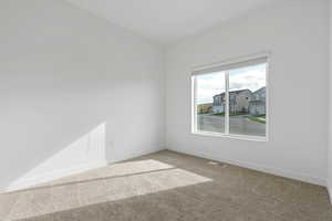 Carpeted spare room with baseboards and visible vents