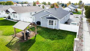 Back of property featuring a residential view, a fenced backyard, a gazebo, a patio area, and a yard