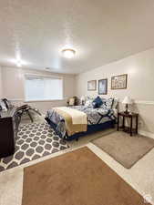 Bedroom with carpet floors, a textured ceiling, and visible vents