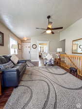 Living room with wood finished floors, a textured ceiling, and ceiling fan