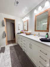 Full bathroom with a shower stall, marble finish floor, vanity, and visible vents