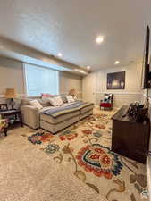 Carpeted living area with recessed lighting, a textured ceiling, and visible vents