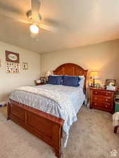 Bedroom with a ceiling fan, carpet flooring, and a textured ceiling