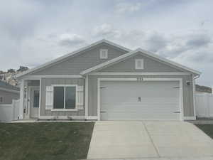 Craftsman house with fence, concrete driveway, board and batten siding, an attached garage, and a front yard