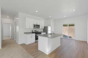 Kitchen with appliances with stainless steel finishes, a sink, a kitchen island with sink, and recessed lighting