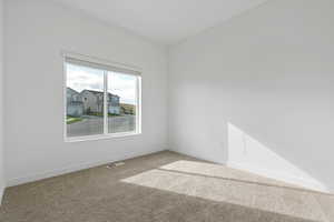 Carpeted empty room with baseboards and visible vents