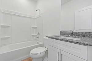 Full bathroom with toilet, vanity, wood finished floors, and tub / shower combination
