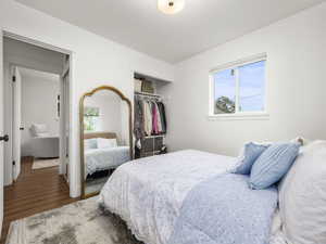 Bedroom with wood finished floors and a closet