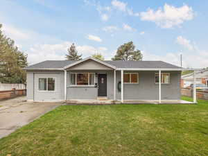 Ranch-style house with fence, a front lawn, and brick siding