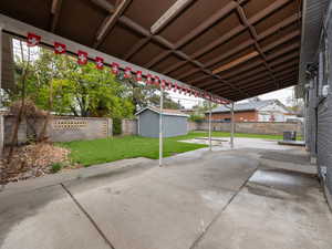 View of patio / terrace featuring a fenced backyard, central air condition unit, and an outbuilding