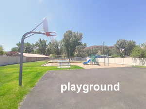 View of basketball court with a yard, community basketball court, fence, and playground community