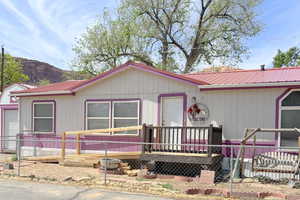 Manufactured / mobile home with fence, metal roof, and Great La Sal mountain view.