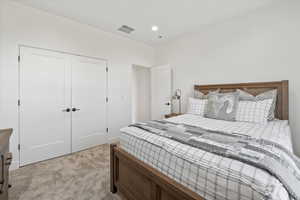 Bedroom with recessed lighting, a closet, visible vents, and light carpet