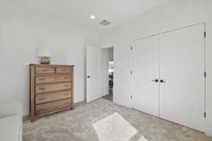 Bedroom with baseboards, visible vents, recessed lighting, light colored carpet, and a closet