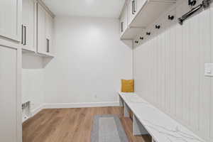 Mudroom with light wood finished floors and baseboards