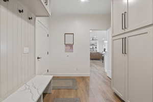Mudroom with light wood-style flooring, baseboards, and recessed lighting