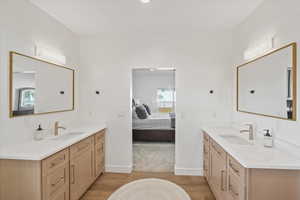 Owner's Ensuite bathroom with two vanities, wood finished floors, and a sink