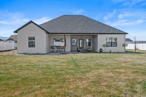 Back of property featuring fence, a yard, and a patio