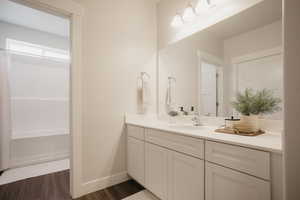 Bathroom featuring baseboards, vanity, and wood finished floors