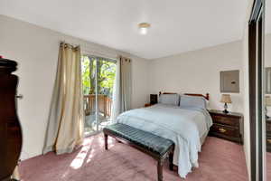 Bedroom featuring carpet floors, electric panel, and access to outside