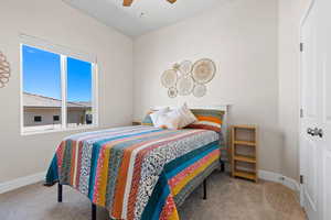 Bedroom with a ceiling fan, baseboards, and carpet