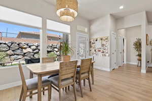 Dining area featuring light wood finished floors, a wealth of natural light, and a chandelier