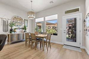 Dining room featuring a chandelier, light wood-style flooring, visible vents, and baseboards