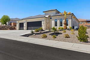 Prairie-style house featuring concrete driveway, an attached garage, a tile roof, and stucco siding