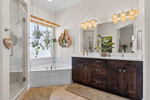 Full bath with double vanity, wood finished floors, a stall shower, and a sink