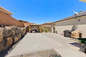 View of patio with fence, grilling area, and a gazebo