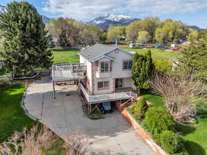 Rear view of property with stucco siding, a deck with mountain view, and a yard