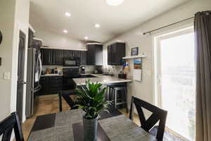 Kitchen with black appliances, a healthy amount of sunlight, and a sink