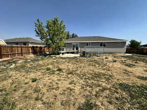 Rear view of house featuring a wooden deck and a fenced backyard