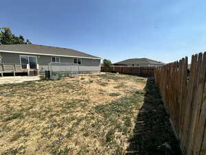 Fenced backyard with a deck